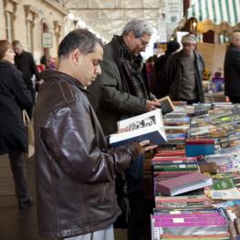 Two men flicking through books at a book stall